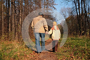 Grandfather and the grandson walk on wood