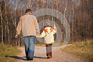 Grandfather and the grandson walk on wood