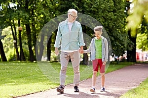 Grandfather and grandson walking at summer park