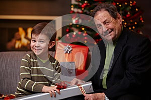 Grandfather and grandson wrapping gifts together