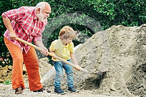 Grandfather with his grandson hard working. Little grandson helping his grandfather with building work. Child and works