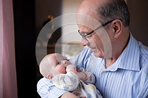 Grandfather holding a beautiful newborn baby girl