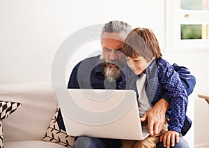 Grandfather, laptop and boy child for games, elearning and bonding in living room. Kids, family and internet for play or