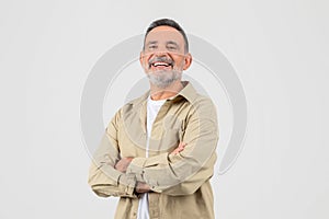 Grandfather laughing with arms crossed on white background