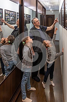 Grandfather and little granddaughters are looking at family photos