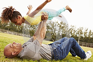 Grandfather Playing Game With Granddaughter In Park