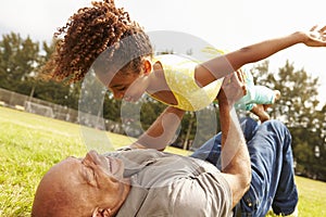 Grandfather Playing Game With Granddaughter In Park