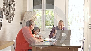 Grandfather playing with a girl while his gay couple working next to them