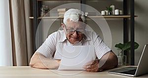 Grandfather reading good news in letter from grownup children