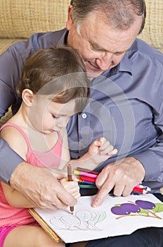 Grandfather reading with granddaughter
