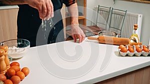 Grandfather sieving flour on wooden table