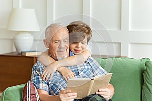 Grandfather sitting on couch with cute grandson