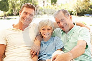 Grandfather, Son And Grandson Relaxing On Sofa