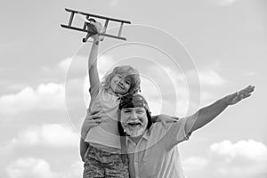 Grandfather and son playing with toy airplane against summer sky background. Weekend with granddad.