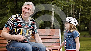 Grandfather spending time with her granddaughter on a park bench