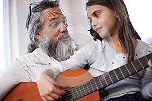 Grandfather teaching girl to play guitar, learning and development in music with help in creativity. Musician, art and