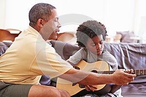 Grandfather Teaching Grandson To Play Guitar photo