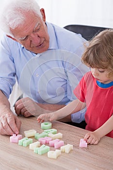 Grandfather teaching preschooler alphabet