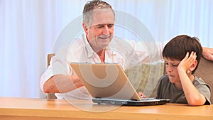Grandfather using a laptop with his grandson