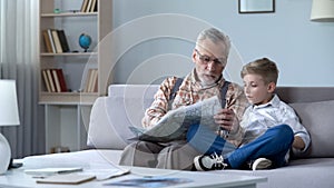 Grandfather veteran viewing map with grandson showing front line remembering war