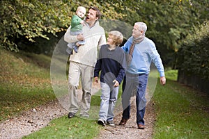 Grandfather walking with son and grandchildren