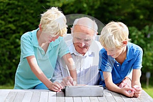 Grandkids teaching grandpa to use tablet pc