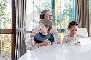 Grandma entertaining her little grandchildren with a tablet computer game