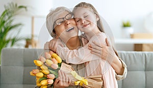 Grandma and girl smiling and hugging