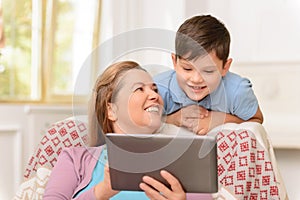 Grandma with grandchild sitting in the armchair