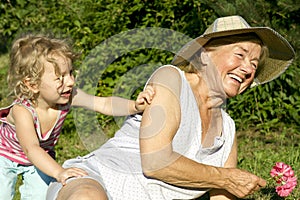 Grandma and granddaughter play in garden