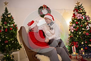 Grandma and Grandpa sit and talk at a Christmas party at home during the holidays