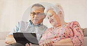 Grandma and Grandpa are sitting on couch in their cozy living room. They are both