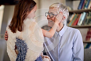 A grandma and her little granddaughter are cuddling each other while spending a time together at home. Family, home, love,