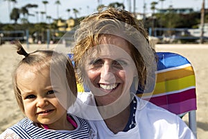 Grandma holding young toddler girl on the beach