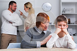 Grandma hugging upset boy during parental quarrel