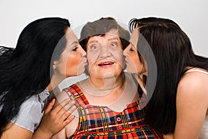 Grandma kissed by two granddaughters photo