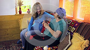 Grandma knit sock talk with pregnant granddaughter in room