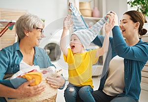 Grandma, mom and child are doing laundry