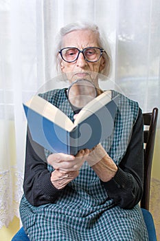 Grandma reading a book through magnifying glass