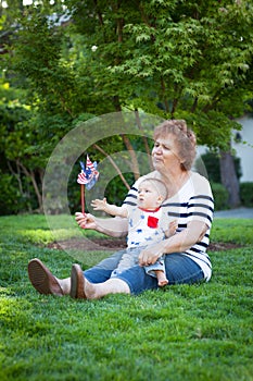 Grandmother and baby boy playing with a pinwheel outside