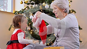 grandmother and baby girl opening christmas gift