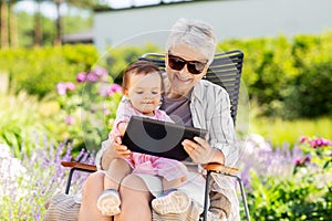 Grandmother and baby granddaughter with tablet pc