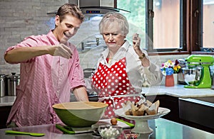 Grandmother baking cupcakes with her grandson