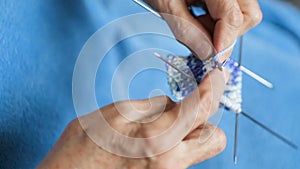 Grandmother in a blue robe knits