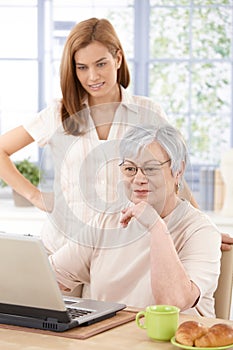 Grandmother browsing internet with granddaughter