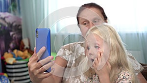 Grandmother and child granddaughter do selfie smartphone. Family, mature woman and girl together