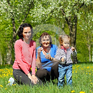 Grandmother, daughter and granddaughter blow bubbles