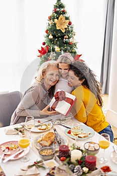 Grandmother, daughter and granddaughter exchanging Christmas presents