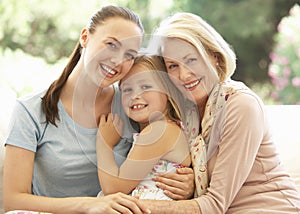 Grandmother With Daughter and Granddaughter Laughing Together On Sofa