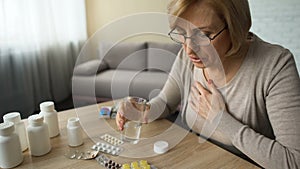 Grandmother drinking prescribed pills for heartache, old lady suffering diabetes